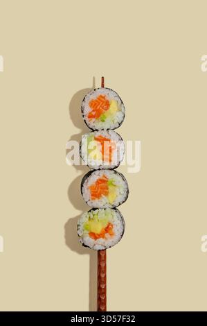 Sushi-Brötchen auf einem chinesischen Stock aufgespießt Stockfoto