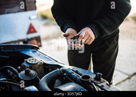 Leitender Mann, der am Motor arbeitet, während er die Ausrüstung inspiziert Stockfoto