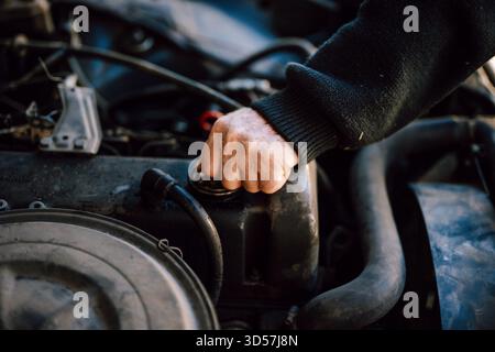 Person, die den Motorölstand in einem Fahrzeug überprüft Stockfoto