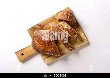 Handwerkliches Brot geschnittenes Holzbrett mit Blick von oben Bäckerei weißer Hintergrund isoliert Stockfoto
