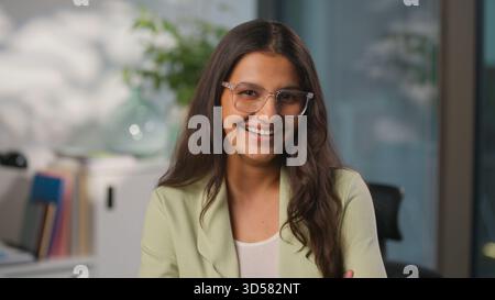 Lächelnd zahniger glücklicher Kopfschuss Ostindische Geschäftsfrau arbeitendes Unternehmensgründungs-CEO im Büro Arabische weibliche Geschäftsfrau Porträt Stockfoto