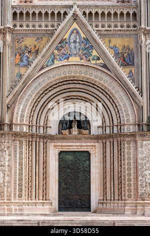 Italien - Orvieto - Duomo di Orvieto - Bronzeportal mit Skulpturen, Marmorbändern und goldenen Mosaiken Stockfoto