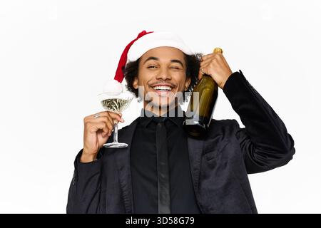 Ein hübscher junger Mann in stilvollem Outfit feiert gern mit Getränken und Weihnachtsstimmung. Stockfoto