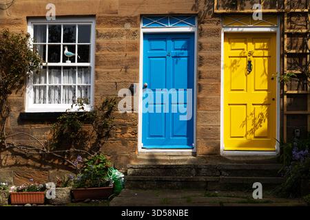 Farbenfrohe Türen in Robin Hood's Bay in North Yorkshire, England. Eine der Türen ist blau und die andere gelb. Stockfoto