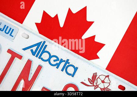 Alberta kanadisches Autokennzeichen auf der Flagge Kanadas Nahaufnahme. Führerschein- und Zulassungskonzept Stockfoto