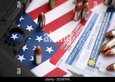 US-Schusswaffenlizenz und Pistole mit Kugeln auf US-Flagge Nahaufnahme. Waffenerlaubnis und Verfassung - zweites Zusatzkonzept Stockfoto