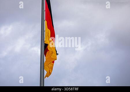 Deutsche Flagge Nahaufnahme vor bewölktem Himmel Stockfoto