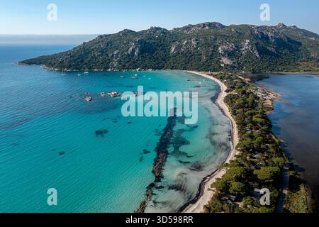 Türkisfarbener Strand entlang der üppig grünen Küste mit klarem Wasser und Bergkulisse, Korsika, Frankreich Stockfoto