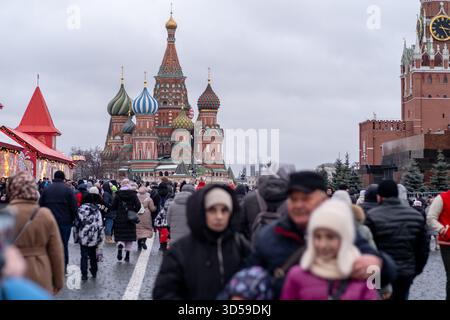 Der geschäftige Platz ist voll von Menschen, die die Basilius-Kathedrale in Moskau während eines bewölkten Tages besuchen Stockfoto