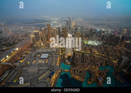 Ein atemberaubender nächtlicher Blick auf Abu Dhabi City von einem der höchsten Türme aus mit glitzernden Wolkenkratzern, beleuchteten Straßen und Reflexionen Stockfoto