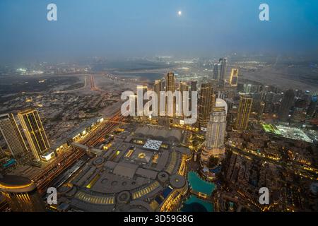 Ein atemberaubender nächtlicher Blick auf Abu Dhabi City von einem der höchsten Türme aus mit glitzernden Wolkenkratzern, beleuchteten Straßen und Reflexionen Stockfoto