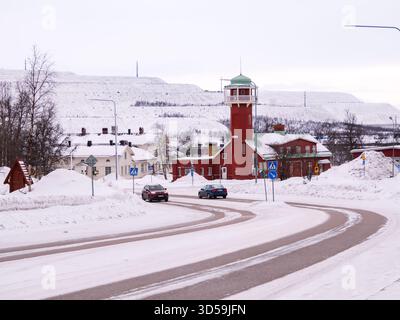 Kiruna, Schweden - 9. März 2023: Das Feuerwehrgebäude im ehemaligen Stadtzentrum von Kiruna mit den schneebedeckten Hügeln des Eisenerzbergwerks im Ba Stockfoto