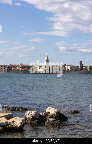 Porec, Kroatien, Istrien - 25. September 2023: Blick von der Nikole Tesle Straße auf das Meer mit Glockenturm byzantinischer Architektur Euphrasischer Basilika Stockfoto