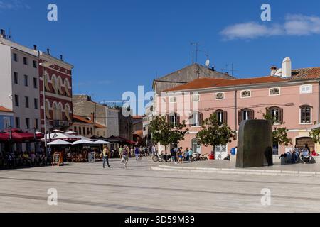 Porec, Kroatien, Istrien - 25. September 2023: Freiheitsplatz (Trg Slobode) in der Altstadt, der größte und beliebteste Platz der Stadt. Die Regenstatue Stockfoto