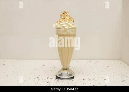 Karotten-Kuchen-Shake mit Frischkäse-Eis, Walnüssen, Zimt und kandierten Karotten Stockfoto