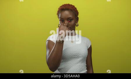 Junge afroamerikanische Frau, die vor gelbem Studiohintergrund mit dem Finger auf die Kamera zeigt; Selbstvertrauen. Stockfoto