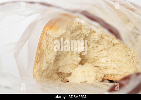 Eine Nahaufnahme von frischem Weizenbrot in einer durchsichtigen Plastiktüte, in der Tüte gebrochen Stockfoto