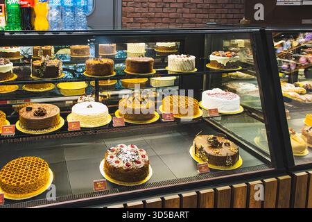 Baku, Aserbaidschan. Das ist eine wunderschöne Auswahl an Kuchen und Gebäck. Das Bild zeigt eine gekühlte Vitrine, die mit mehreren Farbschichten gefüllt ist Stockfoto