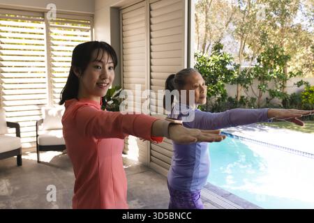 Asiatische Frauen üben Yoga am Pool, genießen Outdoor-Übungen und Entspannung. Fitness, Wellness, Meditation, Zen, Flexibilität, Ruhe Stockfoto