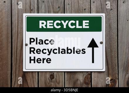 Recyceln – Legen Sie hier ein Schild auf eine Holzoberfläche Stockfoto