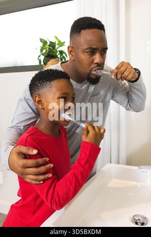 Zähneputzen zusammen, afroamerikanischer Vater und Sohn in der morgendlichen Routine zu Hause Stockfoto