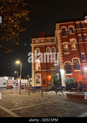 Traditionelles rotes Backsteingebäude mit weißen dekorativen Details, fotografiert bei Nacht im Stadtzentrum von Hull, England, mit Straßenbeleuchtung und leer Stockfoto