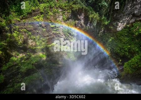 Wunderschöner Regenbogen an einem Wasserfall bei Hochwasser auf dem Langouette River im französischen Jura. Stockfoto