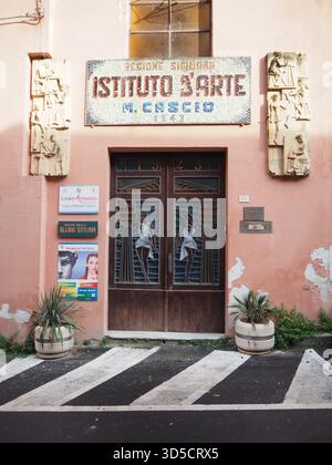 Fassade der Kunstschule mit Mosaikzeichen und Reliefskulpturen im historischen Istituto d’Arte in Enna, Sizilien Stockfoto