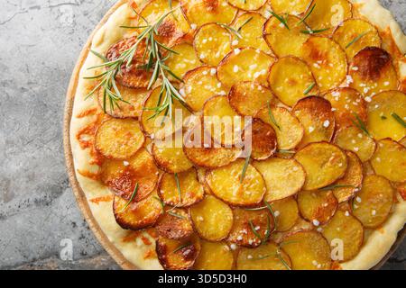 Frisch gebackene Pizza mit Kartoffelgemüse und Rosmarin Nahaufnahme auf dem Holzbrett auf dem Tisch. Horizontale Draufsicht von oben Stockfoto
