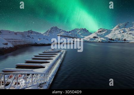 Leerer Pier in einem kleinen Fischerdorf an der Sundstraumen Straße und Kakernbrücke bei Nacht mit Nordlichtern. Lage: Flakstadoya Insel, Lofoten; NOR Stockfoto
