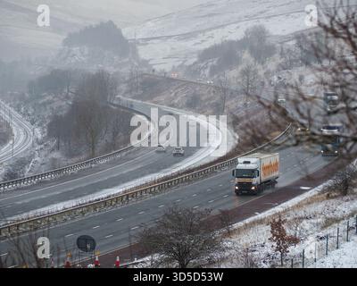 Lkw und Autos auf der Autobahn M6 in der Nähe der Lune Valley Gorge in der Nähe von Tebay an einem Wintertag - die Felder und die Landschaft mit Schnee bedeckt Stockfoto
