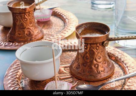 Kaffee serviert in traditionellem Kupferkaffee. Türkischer Kaffee, arabischer oder bosnischer Kaffee. Stockfoto