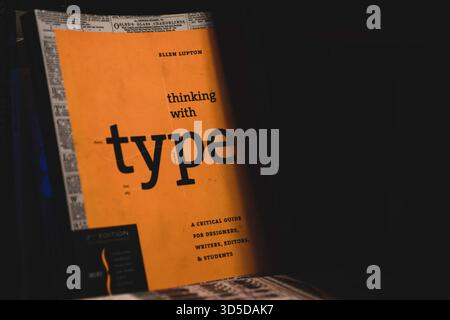 Eine dramatische Aufnahme des Buchumschlags „Thinking with Type“ bei schlechten Lichtverhältnissen mit Schwerpunkt auf Typografie und grafischen Designelementen. Stockfoto