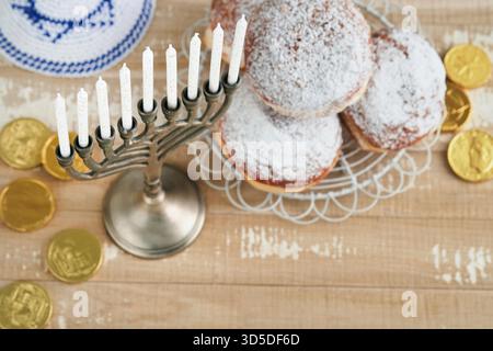 Happy Hanukkah. Hanukkah alte Menorah vor dem Hintergrund der israelischen Flagge mit Sonnenlicht oder Bokeh auf weißem hölzernem Hintergrund. Religionsbild des jüdischen Feiertags Hanukkah-Hintergrunds. Stockfoto