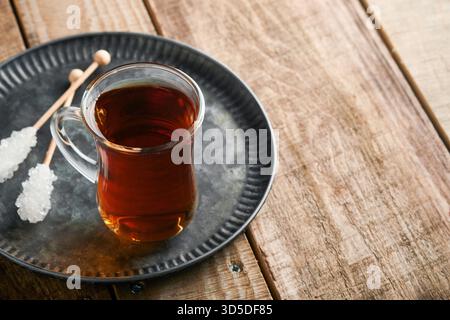Türkischer schwarzer Tee. Eine Glasschale türkischer schwarzer Tee und knuspriger türkischer traditioneller Bagel auf altem Rustick-Hintergrund. Frühstücksgebäck-Konzept. Traditionelles türkisches Heißgetränk. Stockfoto