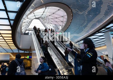 Pendler, die Rolltreppen unter der Kartendecke in der Moynihan Train Hall NYC fahren Stockfoto