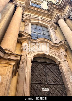 Ein atemberaubender barocker Kircheneingang mit großen Säulen, geschnitzten Steindetails und einem kunstvoll verzierten Eingang. Fotografiert in Wrocław, Stockfoto