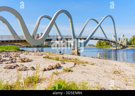 Kiew, Ukraine - 23. September 2025: Die Menschen schlendern entlang des Dnipro in der Nähe der Wellenbrücke in Kiew, während Fischer ihre Leinen werfen. Stockfoto