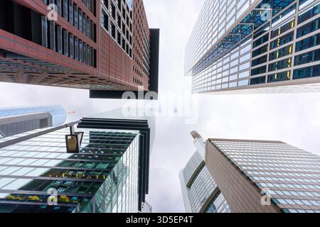 Frankfurt, Deutschland - 21. Oktober 2025: Atemberaubender perspektivischer Blick auf hoch aufragende Wolkenkratzer in Frankfurt unter bewölktem Himmel. Stockfoto
