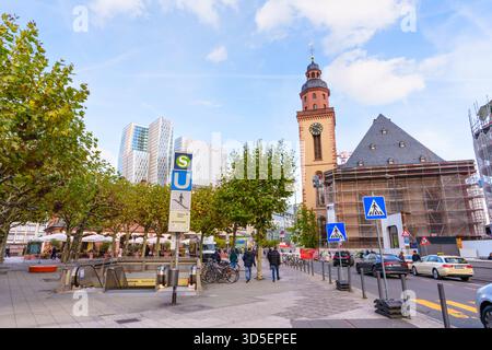 Frankfurt, Deutschland - 21. Oktober 2025: Die historische Katharinenkirche, teilweise renoviert, steht im Kontrast zu modernen Wolkenkratzern und einem geschäftigen Treiben Stockfoto