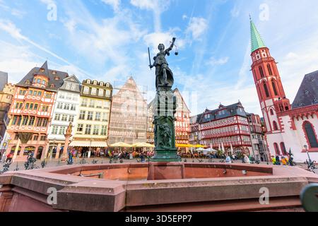 Frankfurt, Deutschland - 21. Oktober 2025: Justitia Statue über Frankfurts geschäftigem Romerberg Platz, flankiert von malerischen historischen Gebäuden und Stockfoto