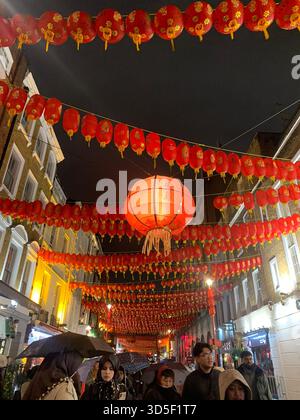 Festliche rote chinesische Laternen schmücken Chinatown im Zentrum von London bei Nacht und schaffen eine lebendige kulturelle Atmosphäre. Stockfoto