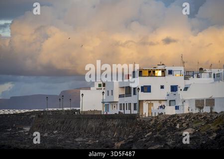 Typische weiße Häuser in der Stadt La Santa an der Küste, bei Sonnenuntergang, Lanzarote, Kanarische Inseln, Spanien Stockfoto