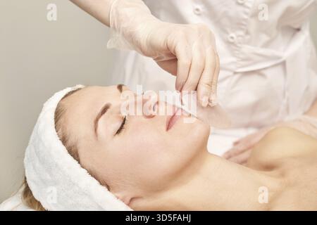 Arzt, der Hautroutine macht. Salongeburtschaftsbehandlung. Gesundheitskonzept. Weibliche Person. Pandemische guasha Akupunktur Gesichtsmassage. Anti-Age-Verfahren Stockfoto
