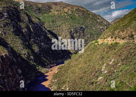 Die kontrastreichen Farben des Flusses und die üppige Vegetation an den Berghängen schaffen eine atemberaubende natürliche Landschaft Stockfoto