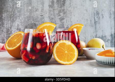 Erfrischender Sommer-Sangria-Cocktail mit Früchten und Beeren in Gläsern auf dem Tisch Stockfoto
