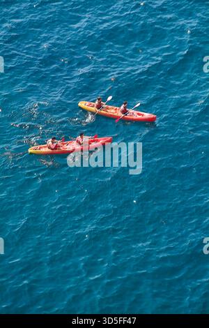 Dubrovnik. Kroatien - 15. November 2025: Aus der Vogelperspektive einer Gruppe von Freunden in zwei Tandemkajaks, die auf dem glitzernden blauen Meer paddeln. Konzept des Abenteuers Stockfoto
