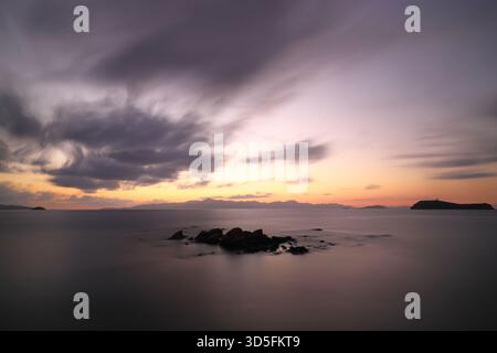 Ein kleiner Felsen bei Sonnenuntergang in der Ägäis. Langbelichtungstechnik. Selektiver Fokus. Stockfoto