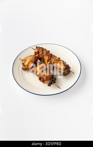 Gegrillte Hähnchenspieße auf einem weißen Teller, Studioaufnahme mit Kebab-Schaschlik, fertig zum Servieren Stockfoto