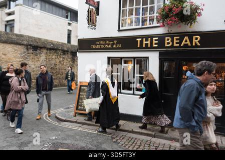 Ein Absolvent der Oxford University, der am Bear Inn Pub und Restaurant in Oxford, Großbritannien, vorbeiläuft Stockfoto